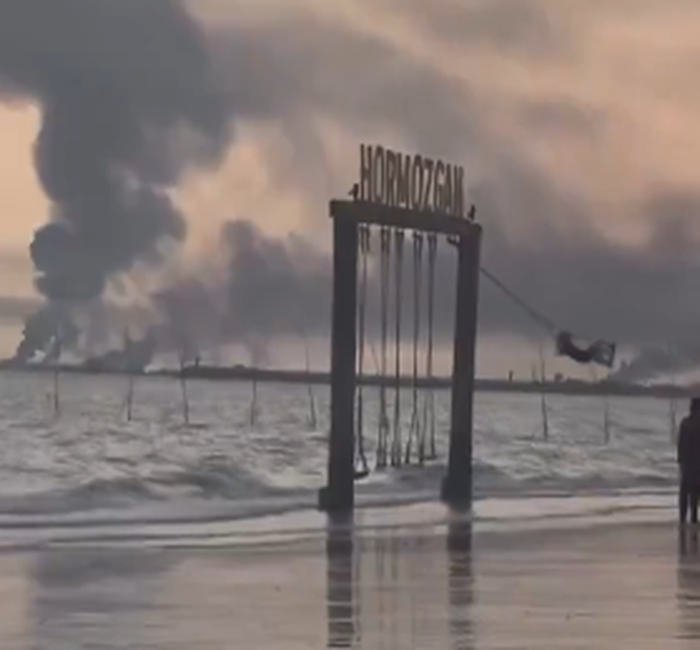 Παιδί κάνει κούνια με φόντο καπνούς πολέμου